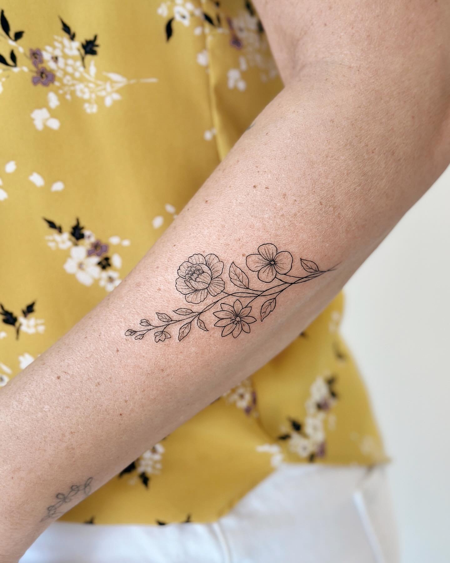 Fine line botanical branch tattoo by CHA