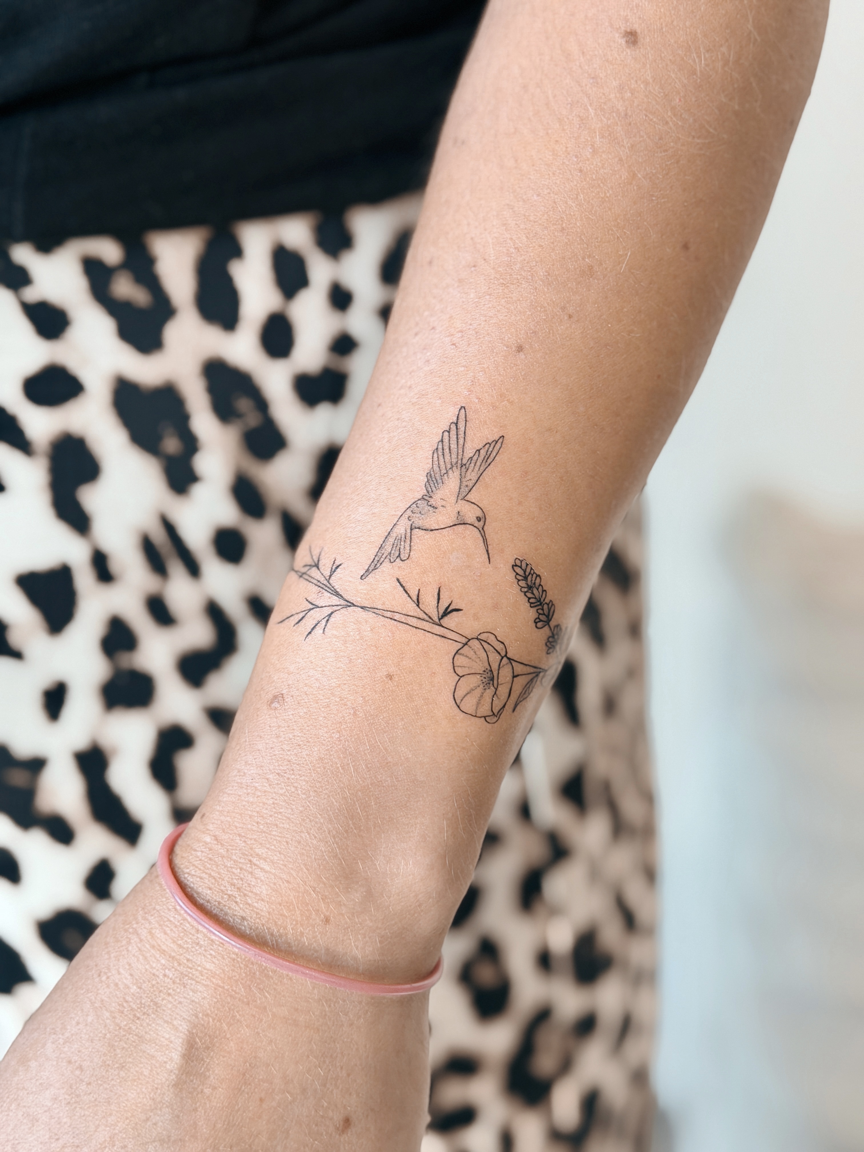 Fine line hummingbird and floral tattoo by CHA