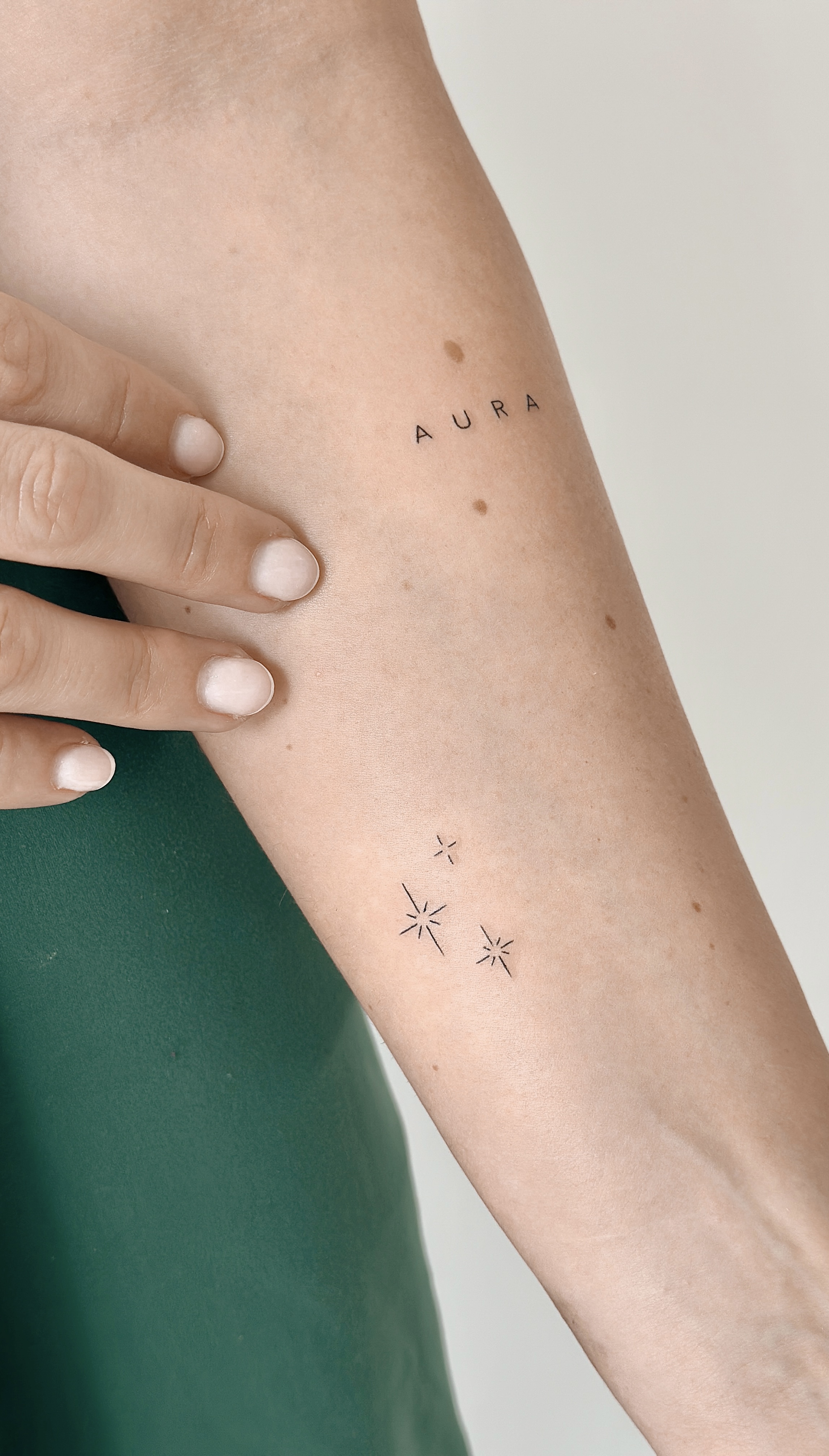 Fine line Aura script tattoo with small stars