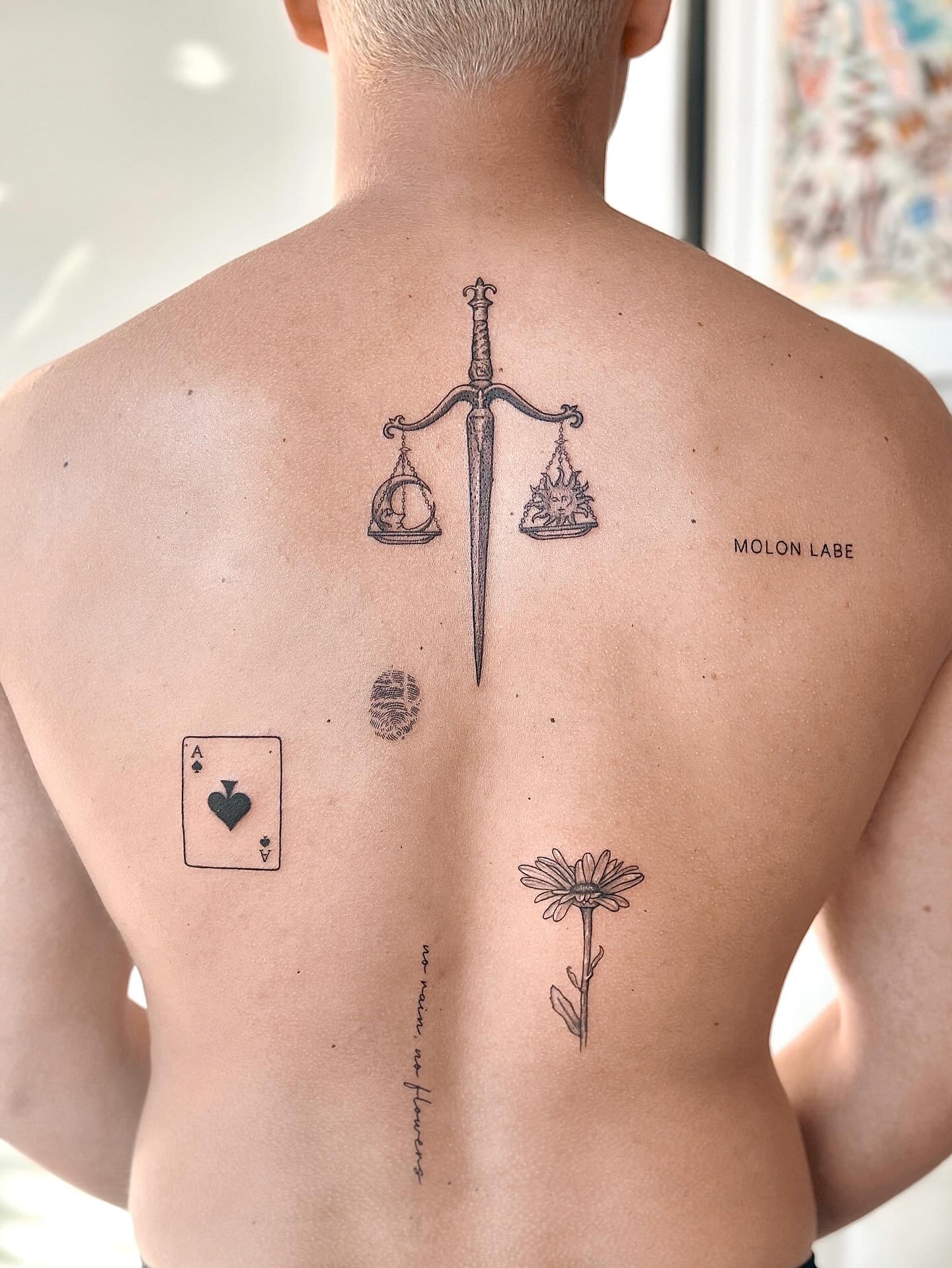 Fine line sword and scales back tattoo
